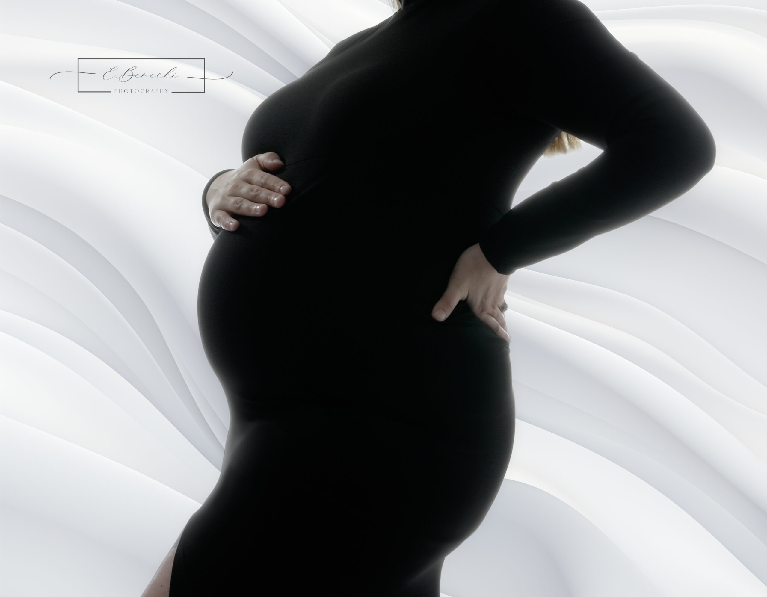 Mom to be wearing a black fitted dress for her pregnancy photoshoot near Seattle. Image by E. Benecki Photography